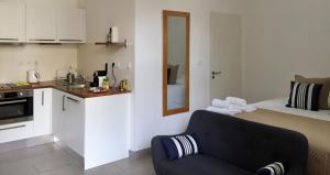 a living room with a blue couch and a kitchen at Le Clos des Salins in Toulouse