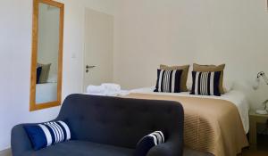 a bedroom with a bed with a couch and a mirror at Le Clos des Salins in Toulouse