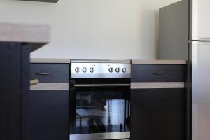 a kitchen with a stove and a refrigerator at Villa Tatranit in Nová Lesná