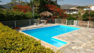 a swimming pool with blue water in a yard at Sítio Gazotti Marina in Capitólio