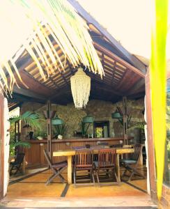 a dining room with a table and chairs and a chandelier at Paua Hotel Boutique in Pipa
