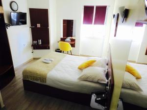 Un ou plusieurs lits dans un hébergement de l'établissement Massilia hôtel