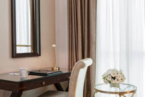 a desk with a mirror and a table with a chair at Elite World Istanbul Florya in Istanbul