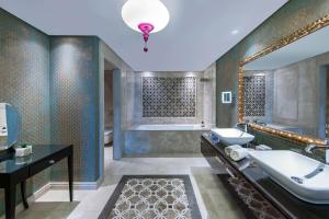 a bathroom with a tub and a sink and a mirror at Elite World Istanbul Florya in Istanbul