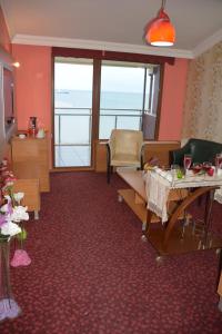 a room with a table and chairs with a view of the ocean at Hopa Heyamo Hotel in Hopa