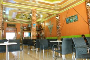 a dining room with tables and chairs and orange walls at Hotel Espace Tifawine in Tafraout