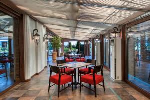 a dining room with a table and red chairs at Elite World Istanbul Florya in Istanbul