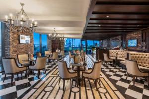 a restaurant with chairs and a bar with windows at Elite World Istanbul Florya in Istanbul