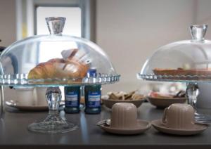 una mesa con un plato de comida y un plato de vidrio con pan en Accademia 21, en Mantua