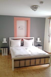 1 dormitorio con 1 cama grande con sábanas blancas en Weinhaus Kurtrierer Hof, en Leiwen