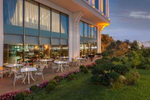 a restaurant with tables and chairs outside of a building at Elite World Istanbul Florya in Istanbul