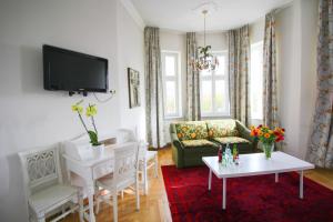 ein Wohnzimmer mit einem Sofa und einem TV in der Unterkunft Hotel Seibel in München