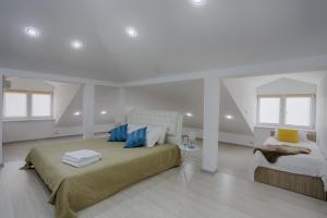a white bedroom with two beds with blue pillows at Yakovlev hotel in Irkutsk