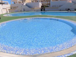 a large swimming pool with blue tiles on the ground at Poligono - Playa San Fernando in Oliva