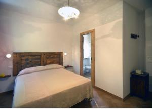 a bedroom with a bed and a chandelier at Agriturismo Vallonga in Poggio San Vicino +9 photos