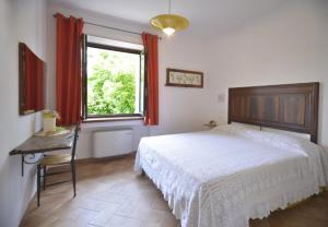 a bedroom with a bed and a table and a window at Agriturismo Vallonga in Poggio San Vicino