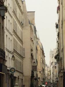 a city street with buildings and people walking down the street at Marais Romantique Paris centre 4 chambres in Paris