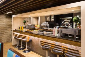 a restaurant with a bar with stools in front of it at Regente Palace Hotel in Buenos Aires