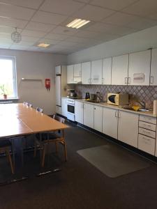 a large kitchen with a table and a table and chairs at Fjordlyst Hotel in Aabenraa