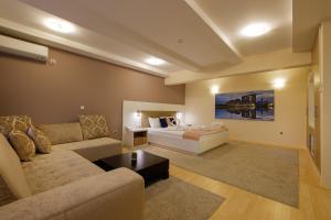 a living room with a bed and a couch at Airport Hotel Garni in Belgrade