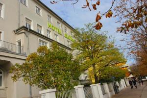 un edificio con una señal verde en el costado. en Hotel Seibel en Múnich