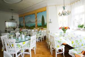 een eetkamer met witte tafels en witte stoelen bij Hotel Seibel in München