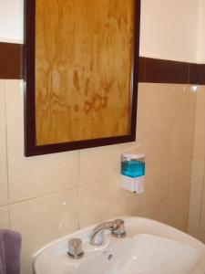 - Baño con lavabo y espejo en Hostel Los Viajeros en El Chaltén