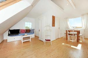 ein weißes Wohnzimmer mit einer Couch und einem Tisch in der Unterkunft Landhaus Meer in Neuharlingersiel