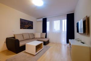 a living room with a couch and a tv at Airport Hotel Garni in Belgrade