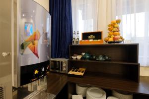 a room with a television and a table with plates at Airport Hotel Garni in Belgrade