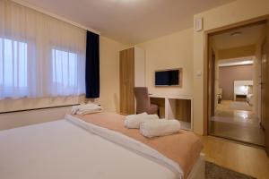 a bedroom with a large bed with white towels on it at Airport Hotel Garni in Belgrade