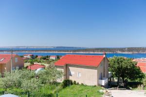 una casa con techo rojo en una colina en House Ljerka en Barbat na Rabu