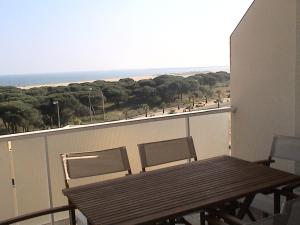 イスラ・クリスティナにあるPinar y Marのバルコニー(木製のテーブルと椅子付)、ビーチが備わります。