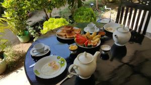 a blue table with plates of food and tea pots at Green Garden Guest Mirissa in Mirissa