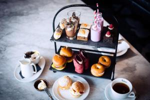 a table with a tray of pastries and cups of coffee at Malmaison London in London