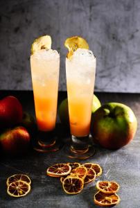 two drinks with oranges and apples on a table at Malmaison London in London
