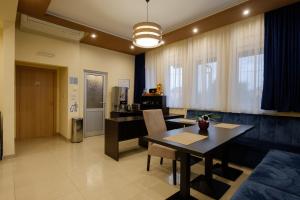 a living room with a dining table and a kitchen at Airport Hotel Garni in Belgrade