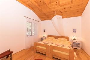 a bedroom with a bed and a wooden ceiling at House Silvestra in Borovići