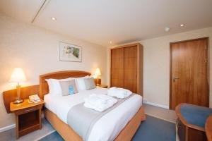 a hotel room with a bed, desk, chair and a lamp at Arora Hotel Gatwick/Crawley in Crawley