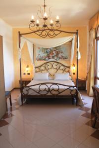 a bedroom with a canopy bed with a chandelier at Hotel Medusa in Lampedusa