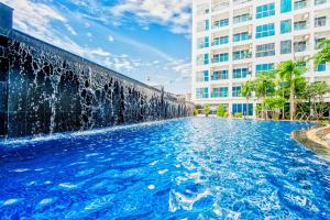 a water fountain in front of a building at Nam Talay Jomtien Beach - Rooftop Ocean View - Close to Beach, Pool & Gym in Na Jomtien
