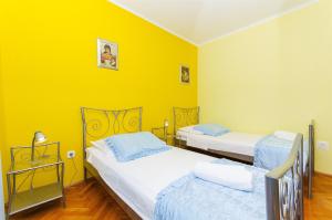 2 camas en una habitación con paredes amarillas en Apartment Kampanel, en Vela Luka