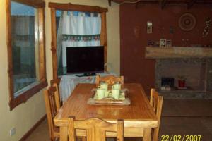 a dining room with a table and a television at El Jarillal in Lago Puelo
