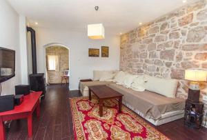 a living room with a couch and a stone wall at House Stone house island Prvic in Prvić Šepurine