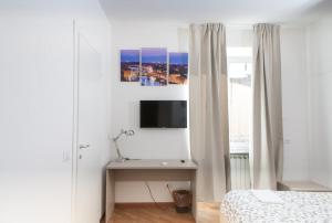 a bedroom with a bed and a desk with a tv at Le Tre Lune Suites in Florence