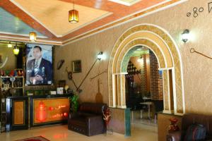 uma sala de estar com televisão e um sofá num quarto em Hotel Espace Tifawine em Tafraoute