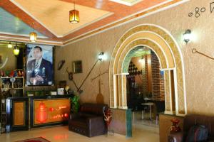 a living room with a tv and a couch in a room at Hotel Espace Tifawine in Tafraoute