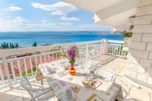 a table on a balcony with a view of the ocean at Apartment Neda in Duće