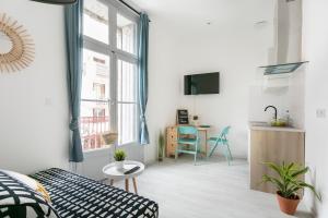 een kamer met een bed en een keuken met een raam bij Studio proche Jean Moulin, location courte durée in Béziers