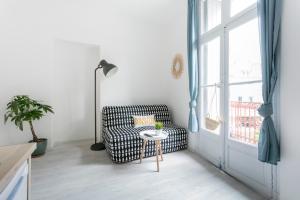 een woonkamer met een stoel en een raam bij Studio proche Jean Moulin, location courte durée in Béziers